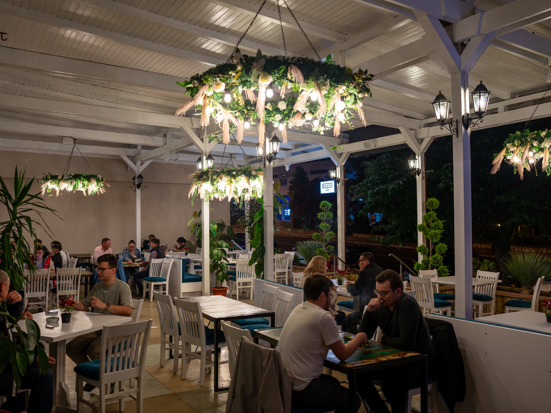 Terasa cu pergolă albă și candelabre florale, seara