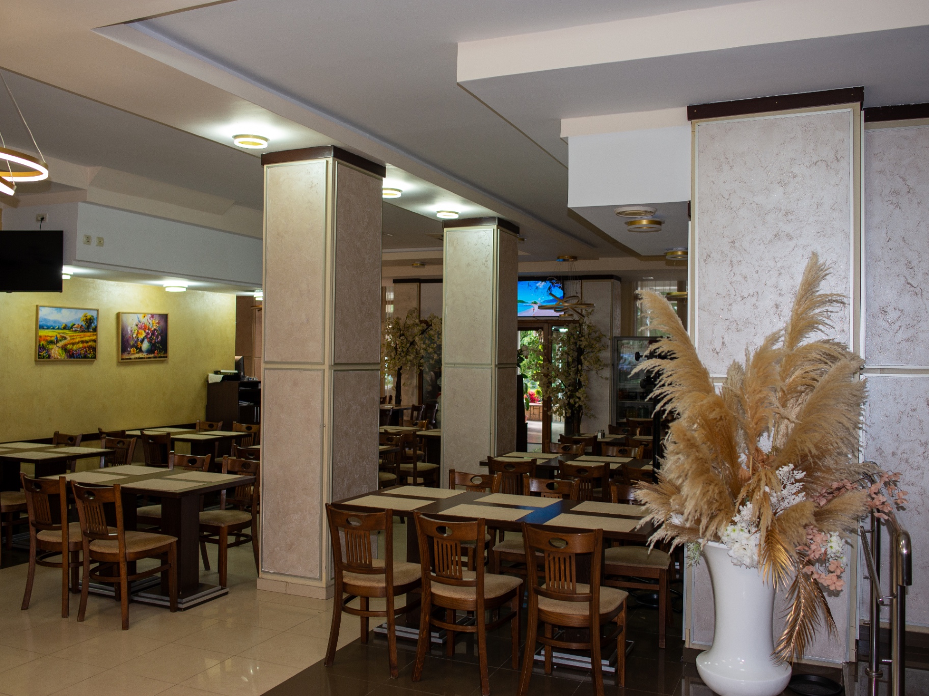 Sala interioară a restaurantului cu mese de lemn